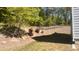 Landscaped backyard featuring terraced retaining walls, metal fence, trees, and bushes at 705 Blue Pointe Path, Apex, NC 27523
