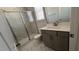 Bathroom with glass enclosed walk-in shower, white and gray tiling, and a gray vanity at 705 Blue Pointe Path, Apex, NC 27523