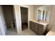 Bathroom featuring marble-tiled floors, gray cabinets, a sink, and a walk-in closet at 705 Blue Pointe Path, Apex, NC 27523