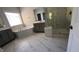 Elegant bathroom features marble-tiled floors, gray cabinets, a soaking tub, and a glass-enclosed shower at 705 Blue Pointe Path, Apex, NC 27523