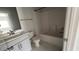 Bathroom featuring marble-tiled floors, gray cabinets, a sink, a toilet, and a tub at 705 Blue Pointe Path, Apex, NC 27523