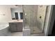 Elegant bathroom features marble-tiled floors, gray cabinets, a soaking tub, and a glass-enclosed shower at 705 Blue Pointe Path, Apex, NC 27523