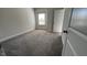 Neutral bedroom featuring gray carpet, a window with blinds, and a white door at 705 Blue Pointe Path, Apex, NC 27523