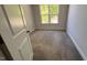 Neutral colored carpeted bedroom with white walls, trim and a window letting in natural light at 705 Blue Pointe Path, Apex, NC 27523