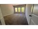 A carpeted bedroom with a window letting in natural light and white walls with painted trim at 705 Blue Pointe Path, Apex, NC 27523