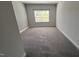 An angle view of a carpeted bedroom with neutral colored walls and painted trim and a window at 705 Blue Pointe Path, Apex, NC 27523