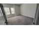 Neutral bedroom featuring gray carpet, and two windows with blinds at 705 Blue Pointe Path, Apex, NC 27523