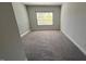 Large bedroom with neutral walls, plush carpeting, and a window provides a serene and peaceful atmosphere at 705 Blue Pointe Path, Apex, NC 27523