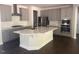 Open kitchen layout with island, stainless appliances, gray cabinetry, and dark hardwood floors at 705 Blue Pointe Path, Apex, NC 27523