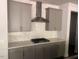 Kitchen with stainless steel range hood and gray cabinets at 705 Blue Pointe Path, Apex, NC 27523
