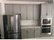 Kitchen featuring stainless steel appliances and gray cabinets at 705 Blue Pointe Path, Apex, NC 27523