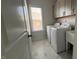 Bright laundry room with white appliances, cabinets and a window at 705 Blue Pointe Path, Apex, NC 27523