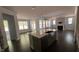 Open-concept living space with dark hardwood floors and kitchen in the background at 705 Blue Pointe Path, Apex, NC 27523