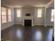 Bright living room featuring dark hardwood floors and a traditional fireplace at 705 Blue Pointe Path, Apex, NC 27523