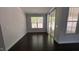 Bright living room featuring dark hardwood floors and access to the outside patio via sliding glass doors at 705 Blue Pointe Path, Apex, NC 27523