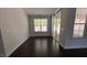 Bright living room features dark hardwood floors, large windows and sliding glass doors to the porch at 705 Blue Pointe Path, Apex, NC 27523