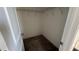 A walk-in closet with neutral carpet, wire shelving, and white walls with painted trim and a door at 705 Blue Pointe Path, Apex, NC 27523