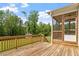 Wooden back deck featuring a screened-in porch, overlooks the lush green backyard with mature trees at 7104 Rex Rd, Holly Springs, NC 27540