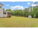 Expansive backyard with green grass, mature trees, and a storage shed at 7104 Rex Rd, Holly Springs, NC 27540