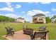 Spacious backyard featuring a patio with outdoor seating and a fire pit with green grass at 7104 Rex Rd, Holly Springs, NC 27540