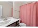 Bathroom featuring a single sink vanity and a shower-tub combination with red and white striped curtain at 7104 Rex Rd, Holly Springs, NC 27540