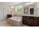 Bathroom with a soaking tub, double vanities, and views to the glass enclosed shower at 7104 Rex Rd, Holly Springs, NC 27540