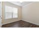 Cozy bedroom featuring dark wood-look flooring and a large window with blinds at 7104 Rex Rd, Holly Springs, NC 27540