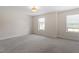 Spacious bedroom with neutral walls, plush carpeting, and natural light from two windows at 7104 Rex Rd, Holly Springs, NC 27540
