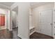 Inviting hallway with coat rack and storage bench, leading to a staircase and doorway at 7104 Rex Rd, Holly Springs, NC 27540