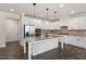 Modern kitchen featuring white cabinets, granite countertops, and stainless steel appliances at 7104 Rex Rd, Holly Springs, NC 27540