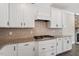 Close up of kitchen featuring white cabinets, granite countertops, and stainless steel appliances at 7104 Rex Rd, Holly Springs, NC 27540