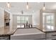 Kitchen island featuring granite countertop and stainless faucet, offering a view of the living area and fireplace at 7104 Rex Rd, Holly Springs, NC 27540