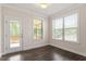 Bright living room with hardwood floors, natural light, and a door leading to the outdoor deck at 7104 Rex Rd, Holly Springs, NC 27540