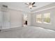 Spacious primary bedroom featuring tray ceilings, carpet, and an en-suite bathroom at 7104 Rex Rd, Holly Springs, NC 27540