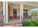 Inviting covered front porch with stone accents and decorative railing provides a welcoming entrance at 7104 Rex Rd, Holly Springs, NC 27540