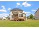 Rear exterior of the house featuring a deck with solar panels, and a spacious backyard at 7104 Rex Rd, Holly Springs, NC 27540