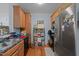 Galley kitchen featuring wood cabinets, stainless steel refrigerator, and black appliances at 712 Portstewart Dr, Cary, NC 27519