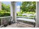 Relaxing porch view with white railing, lush greenery, and a glimpse of parked cars in the background at 712 Portstewart Dr, Cary, NC 27519