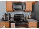 The kitchen boasts wooden cabinets and black appliances, including a microwave and stovetop oven at 712 Portstewart Dr, Cary, NC 27519