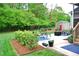 A well-maintained backyard with a shed, greenery, and a comfortable patio at 738 Aspenwood Dr, Graham, NC 27253
