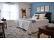 Charming bedroom with a cozy rug, decorative pillows, and an eye-catching blue accent wall at 738 Aspenwood Dr, Graham, NC 27253