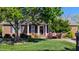 Charming brick home with a lush green lawn, mature trees, and a welcoming front porch at 738 Aspenwood Dr, Graham, NC 27253