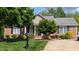 Charming brick home with a well-manicured lawn, mature trees, and inviting curb appeal at 738 Aspenwood Dr, Graham, NC 27253