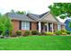 Charming brick home with a well-manicured lawn and mature landscaping at 738 Aspenwood Dr, Graham, NC 27253