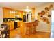 Bright kitchen with wood cabinets, a breakfast bar, and seamless flow into the living area at 738 Aspenwood Dr, Graham, NC 27253