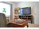 Cozy living room with a large TV, comfortable seating, and floating shelves adding to its charm at 738 Aspenwood Dr, Graham, NC 27253