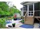 A cozy outdoor patio with a screened in porch and wooden steps at 738 Aspenwood Dr, Graham, NC 27253