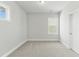 Carpeted bedroom with multiple windows, neutral paint, and a white door at 745 Aristocrat Ln, Knightdale, NC 27545