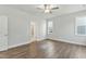 Bright bedroom with wood floors and light gray walls, showcasing a doorway into an ensuite bathroom at 745 Aristocrat Ln, Knightdale, NC 27545