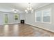 Bright living room featuring a fireplace, wood floors, light gray walls, and a modern light fixture at 745 Aristocrat Ln, Knightdale, NC 27545
